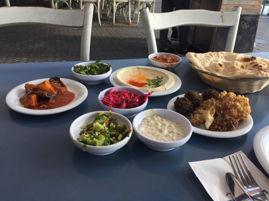 A delicious mix of dips served at the Old Man and the Sea restaurant, featuring creamy hummus, crispy falafel, and fresh tabouli