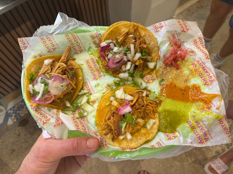 Close-up of tacos de cochinita pibil served on handmade tortillas at Antojitos Yucatecos in downtown Cancun, garnished with pickled red onions.